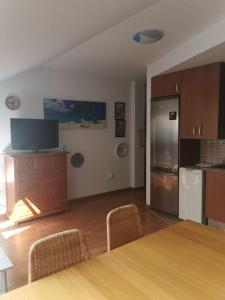 a kitchen with a table with chairs and a refrigerator at Apartamento junto a puerto Fuengirola in Fuengirola