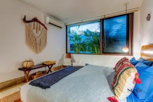 a bedroom with a large bed and a window at Private Rooftop 1BR Condo with Stunning Common Areas in Tulum +22 photos