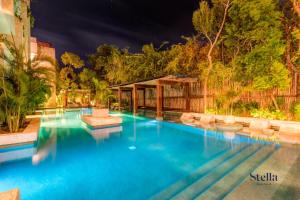 uma piscina com cadeiras e uma cerca em Private Rooftop 1BR Condo with Stunning Common Areas em Tulum