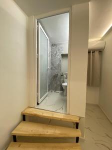 La salle de bains est pourvue d'un miroir et de toilettes. dans l'établissement Kejsi Studios, à Ksamil