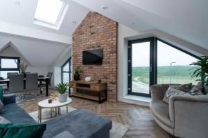 a living room with two couches and a brick wall at 37 West Portrush Luxury Penthouse in Portrush