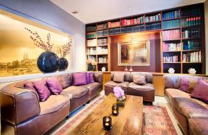 uma sala de estar com um sofá de couro e uma mesa em Alden Suite Hotel Splügenschloss Zurich em Zurique
