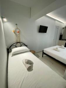 une chambre avec deux lits avec une serviette dessus dans l'établissement Kejsi Studios, à Ksamil