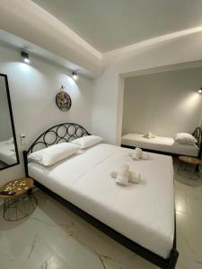 une chambre avec un grand lit blanc avec des serviettes dessus dans l'établissement Kejsi Studios, à Ksamil