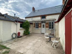 a house with a table and chairs in a courtyard at Maison avec jardin Orléans métropole in Fleury-les-Aubrais