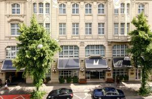een groot gebouw met auto's geparkeerd voor het bij Leonardo Boutique Hotel Düsseldorf in Düsseldorf