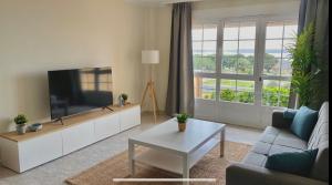 a living room with a couch and a tv at Casa en 1ª línea del mar - House on Sea Front Valdoviño in Valdoviño