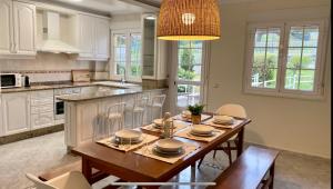 a kitchen with a wooden table with chairs and a dining room at Casa en 1ª línea del mar - House on Sea Front Valdoviño in Valdoviño