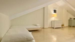 a white bedroom with two beds and a lamp at Casa en 1ª línea del mar - House on Sea Front Valdoviño in Valdoviño