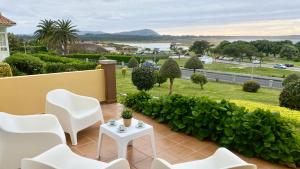 a balcony with white chairs and a view of a park at Casa en 1ª línea del mar - House on Sea Front Valdoviño in Valdoviño