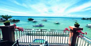 a balcony with a view of the water with boats at On-the-beach JADE's BEACH VILLA 별장 Lapu-lapu Olango 별장 in Lapu Lapu City +23 photos
