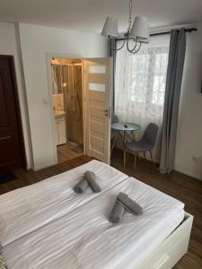 - une chambre dotée d'un grand lit blanc avec 2 oreillers gris dans l'établissement Rodzinna Ostoja, à Zakopane