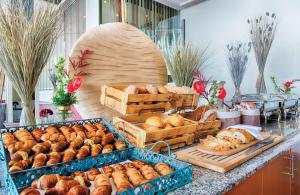 a bakery with many different types of bread on a counter at Leonardo Hotel Mannheim City Center in Mannheim