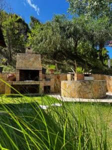 a stone oven in a garden with grass and trees at Armonia Apartments & Studios in Perivolion
