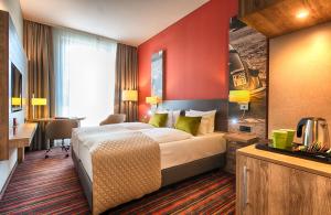 um quarto de hotel com uma cama e uma secretária em Leonardo Hotel Wolfsburg City Center em Wolfsburg