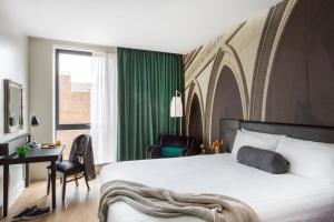 um quarto com uma cama, uma secretária e uma janela em Hotel Indigo Newcastle, an IHG Hotel em Newcastle upon Tyne