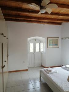 een slaapkamer met een bed en een plafondventilator bij Evgenia's Traditional House in Logothetiánika