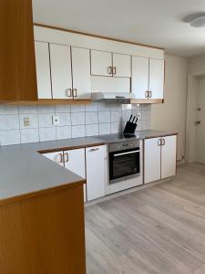 a kitchen with white cabinets and a stove top oven at IQ Apartments 2 in Keflavík