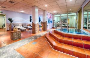 eine große Lobby mit einem Whirlpool in einem Zimmer in der Unterkunft Leonardo Hotel Mannheim-Ladenburg in Ladenburg