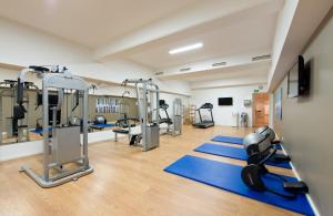 a gym with treadmills and machines in a room at Leonardo Royal Hotel Mannheim in Mannheim