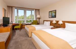 科隆的住宿－科隆波恩機場萊昂納多酒店，酒店客房设有两张床、一张桌子和一台电视。