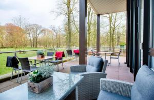 un patio con sillas, mesas y una mesa de cristal en Leonardo Hotel Hannover, en Hannover