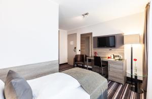 ein Hotelzimmer mit einem Bett und einem Schreibtisch in der Unterkunft Leonardo Hotel Nürnberg in Nürnberg