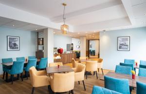 - une salle d'attente avec des tables et des chaises bleues dans l'établissement Leonardo Hotel Nürnberg, à Nuremberg