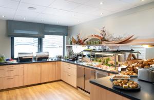 a large kitchen with aasteryasteryasteryasteryasteryasteryasteryasteryasteryasteryastery at Leonardo Hotel Nürnberg in Nuremberg