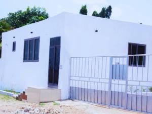 a white building with a gate and a fence at Evame Studio Apartment 