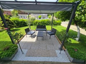 a patio with a table and chairs under a canopy at Apartmani Habibi in Jalžabet
