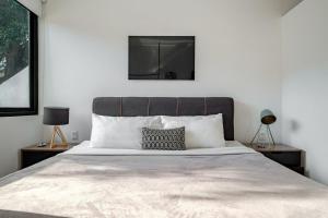 a bedroom with a large white bed with two lamps at Comfortable & Cozy Apartment Reforma Avenue in Mexico City