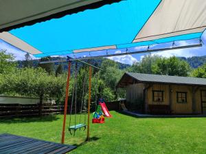 a swing set in a yard with a house at Apartma Lara in Bled