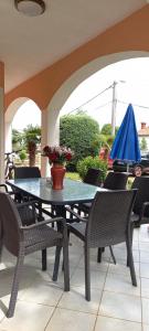 a patio table with chairs and a blue umbrella at Apartment Antonio in Santalezi +13 photos