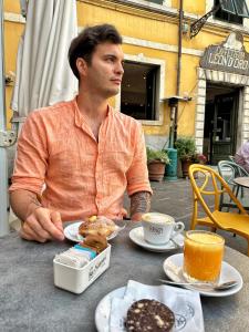 Un uomo seduto a un tavolo con un piatto di cibo di Sky Room - Carrara Nel ex Convento delle Suore a Carrara