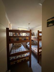a room with three bunk beds in a room at Condominio Parque Del Volcán in Pucón