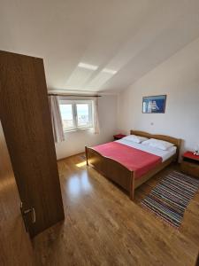 1 dormitorio con 1 cama con manta roja en Apartment in Duce with sea view, balcony, air conditioning, W-LAN 5067-5, en Duće