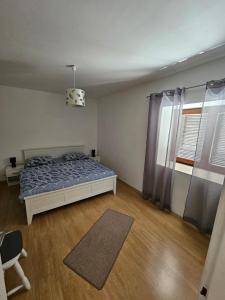 a bedroom with a bed and a chair and a window at Holiday Home Nena in Drniš