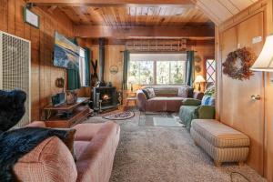 een woonkamer met banken en een open haard bij Big Bear Cabin 4U - Fenced yard on heavily treed lot, experience a true Big Bear Cabin! in Big Bear Lake