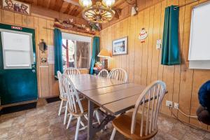 een eetkamer met een houten tafel en stoelen bij Big Bear Cabin 4U - Fenced yard on heavily treed lot, experience a true Big Bear Cabin! in Big Bear Lake