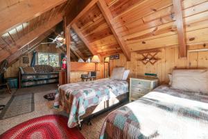 een slaapkamer met 2 bedden in een hut bij Big Bear Cabin 4U - Fenced yard on heavily treed lot, experience a true Big Bear Cabin! in Big Bear Lake