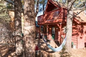 een blokhut met een hangmat voor twee bomen bij Big Bear Cabin 4U - Fenced yard on heavily treed lot, experience a true Big Bear Cabin! in Big Bear Lake