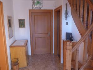 a hallway with a wooden door and a staircase at Haus Mayer in Weilheim in Oberbayern +18 photos