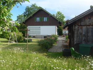 un jardín con un granero y un columpio en Haus Mayer en Weilheim in Oberbayern