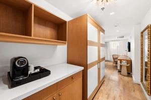 a kitchen with wooden cabinets and a counter top at Hotel Ocean in Miami Beach