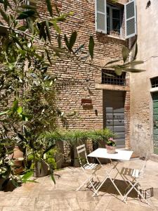 une table et des chaises devant un bâtiment en briques dans l'établissement Casa Valeria - Guest House Centro Storico, à Fano
