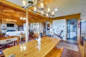 a living room with a wooden table and a large room with a wheel at Tallassee Family Home with Stunning Smoky Mtn Views in Tallassee