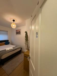 a door to a bedroom with a bed in a room at Manor Court in London