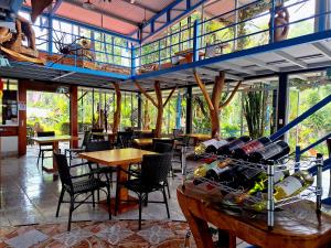 un restaurante con mesas y sillas y una mesa con botellas de vino en Talamanca Nature Reserve en Rivas