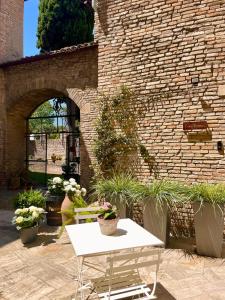une table et un banc blancs devant un mur de briques dans l'établissement Casa Valeria - Guest House Centro Storico, à Fano